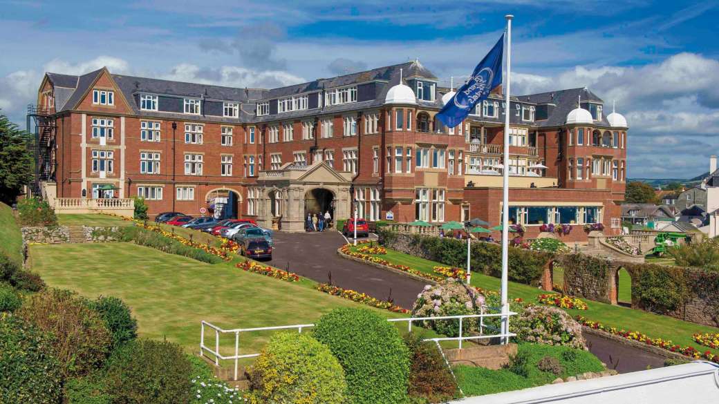 Victoria Hotel External View with Flag and Gardens