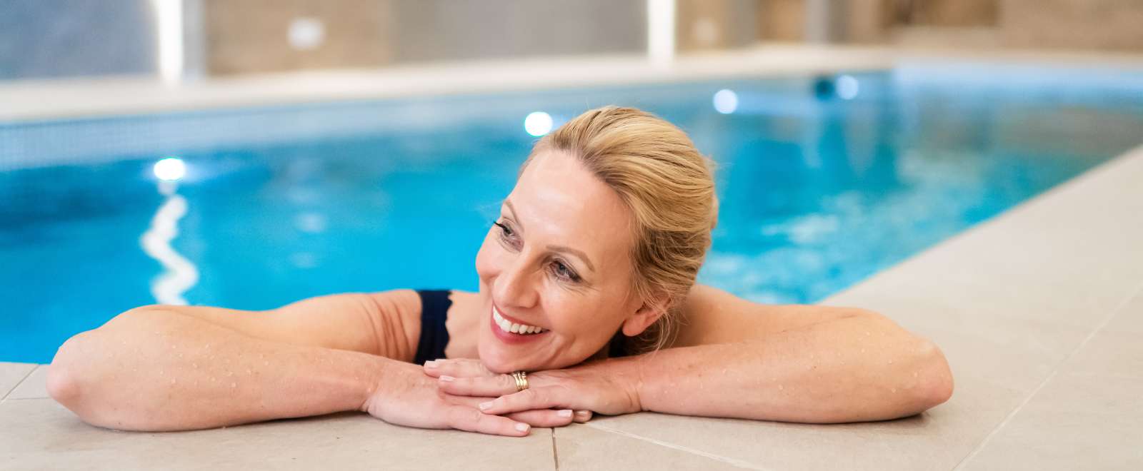 women smiling on edge of pool