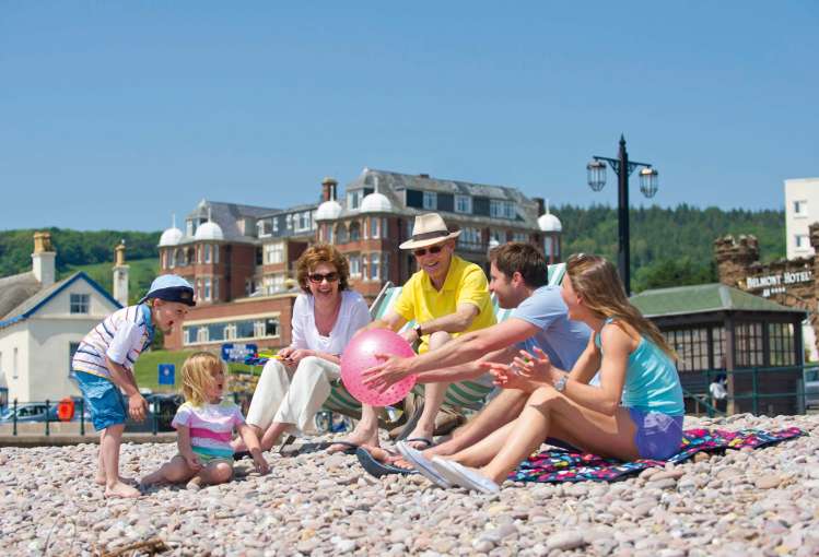 Victoria Hotel Family Sitting on Beach with Hotel in Background