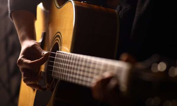 Man Playing Guitar at Folk Event