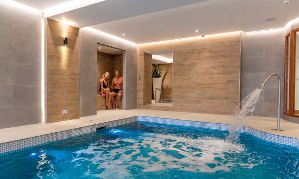 couple in seating area by pool